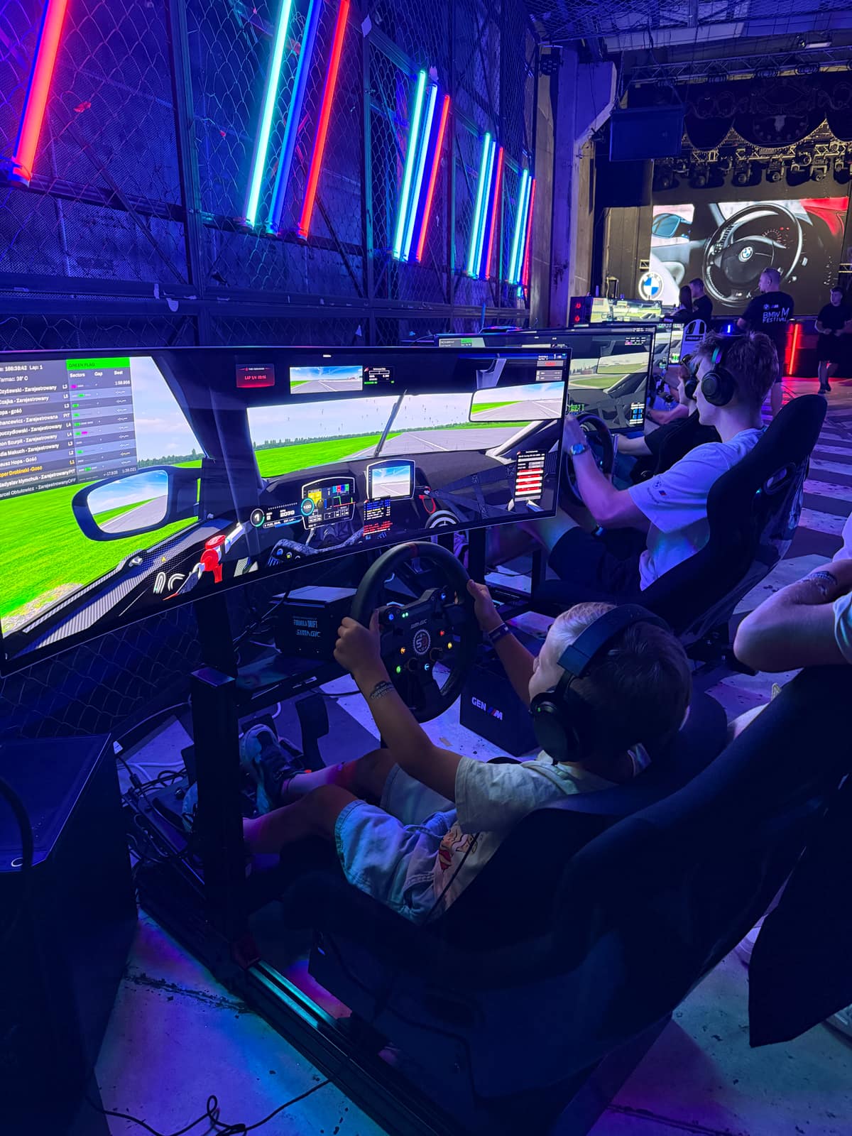 Visitors seated at the simulators, seen from behind, racing at the same time