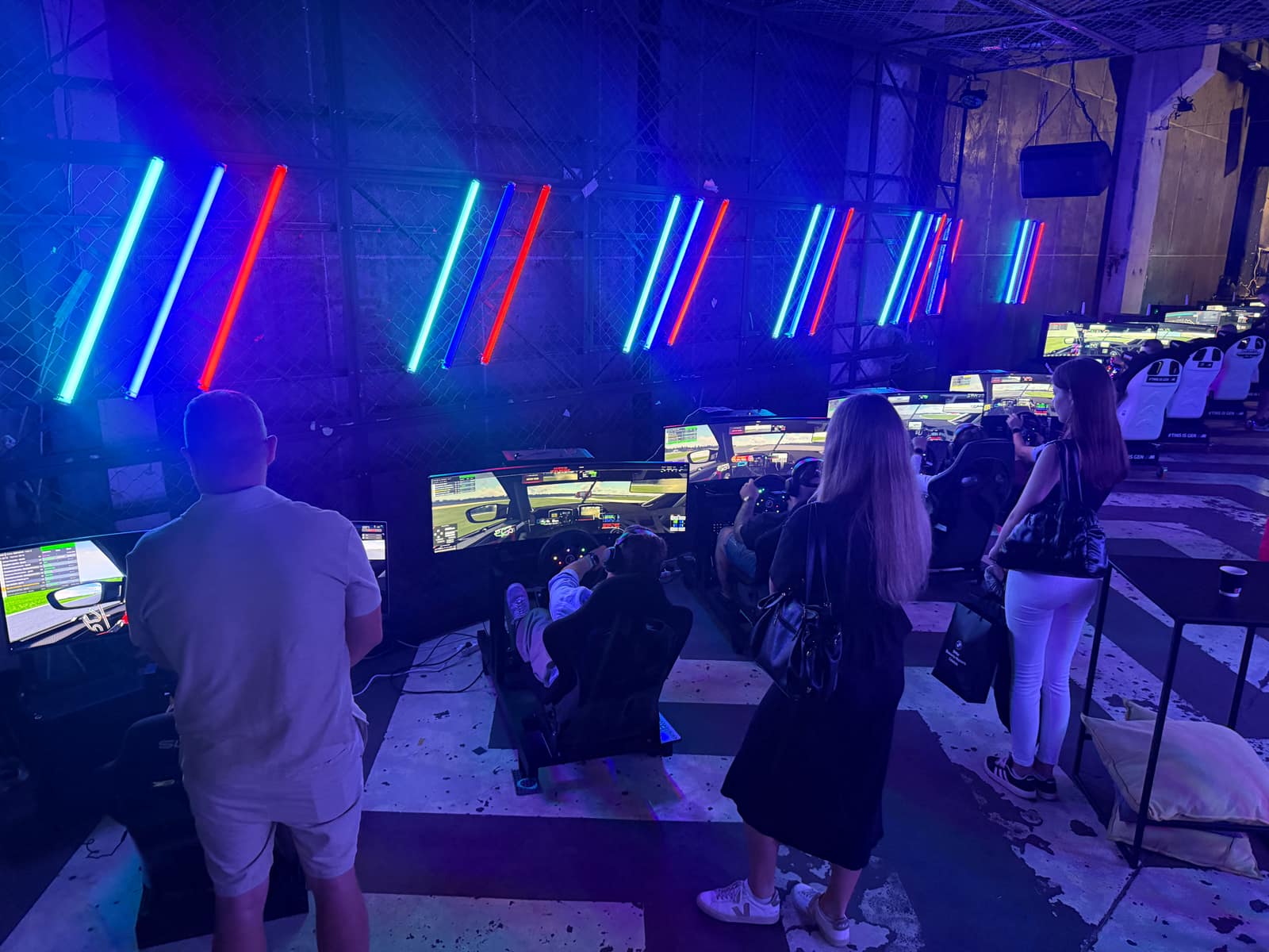 Visitors gathered around the stand watching the simulators, seen from behind