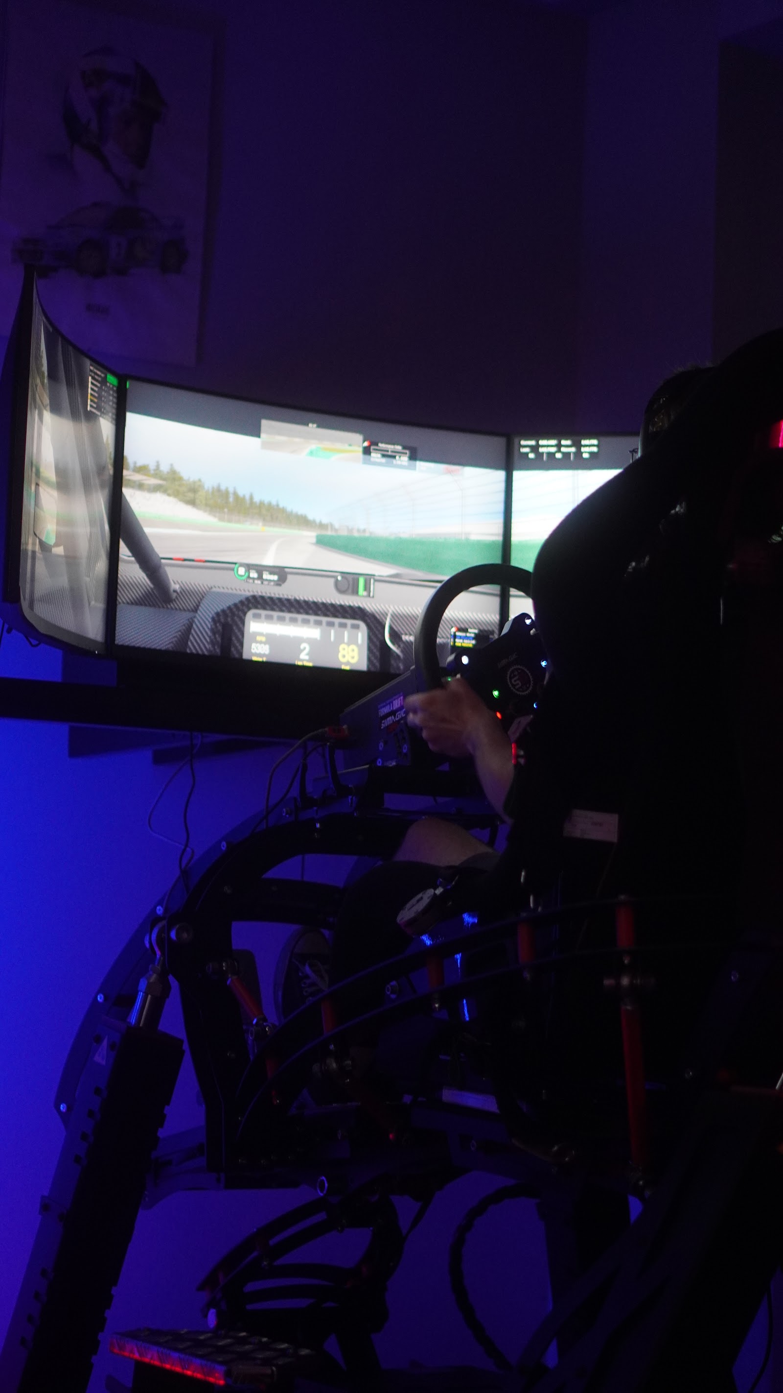 A triple-screen simulator rig between sessions, the track loaded and waiting